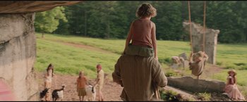 Movie still from “The Divergent Series: Insurgent” (2015), directed by Robert Schwentke – A child is riding on the back of an older man; Medium shot, Over the shoulder angle