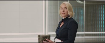 Movie still from “The Divergent Series: Insurgent” (2015), directed by Robert Schwentke – A woman in a black jacket holding a book; Medium shot, Over the shoulder angle