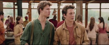 Movie still from “The Divergent Series: Insurgent” (2015), directed by Robert Schwentke – Two young men standing next to each other in front of a building; Close Up shot, Over the shoulder angle