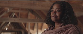 Movie still from “The Divergent Series: Insurgent” (2015), directed by Robert Schwentke – A black woman with a brown scarf is looking at the camera; Close Up shot, Low angle