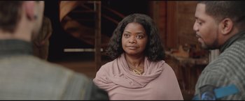 Movie still from “The Divergent Series: Insurgent” (2015), directed by Robert Schwentke – A black woman with long black hair wearing a pink top; Close Up shot, Over the shoulder angle