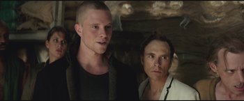 Movie still from “The Divergent Series: Insurgent” (2015), directed by Robert Schwentke – Two men standing next to each other in front of a wall; Close Up shot, Low angle