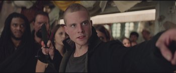 Movie still from “The Divergent Series: Insurgent” (2015), directed by Robert Schwentke – A young man with a shaved head looks into the camera; Close Up shot, Low angle