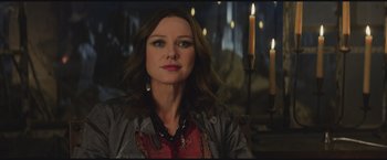 Movie still from “The Divergent Series: Insurgent” (2015), directed by Robert Schwentke – A woman with long brown hair sitting in front of candles; Close Up shot, Over the shoulder angle