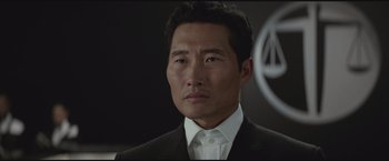 Movie still from “The Divergent Series: Insurgent” (2015), directed by Robert Schwentke – A person wearing a suit and tie; Close Up shot, Over the shoulder angle