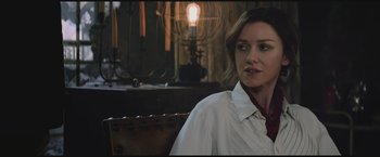 Movie still from “The Divergent Series: Insurgent” (2015), directed by Robert Schwentke – A woman sitting in front of a lamp in a dimly - lit room; Close Up shot, Over the shoulder angle