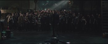 Movie still from “The Divergent Series: Insurgent” (2015), directed by Robert Schwentke – A man standing in front of a crowd in front of an audience; Wide shot, High angle