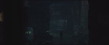 Movie still from “The Divergent Series: Insurgent” (2015), directed by Robert Schwentke – A person standing in a dark room near a cave; Extreme Wide shot, High angle