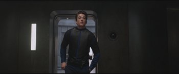 Movie still from “The Divergent Series: Insurgent” (2015), directed by Robert Schwentke – A man standing in front of a door wearing a suit; Medium shot, Low angle