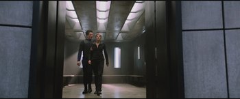 Movie still from “The Divergent Series: Insurgent” (2015), directed by Robert Schwentke – A man and a woman are walking in a room; Wide shot, Low angle