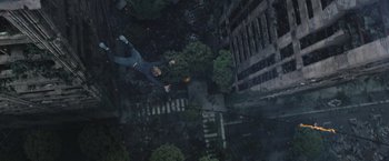 Movie still from “The Divergent Series: Insurgent” (2015), directed by Robert Schwentke – A man flying through the air over a city; Wide shot, Overhead angle