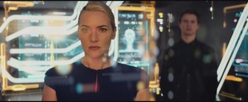 Movie still from “The Divergent Series: Insurgent” (2015), directed by Robert Schwentke – A woman standing in front of an image of a person; Close Up shot, Low angle