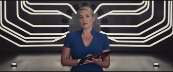 Movie still from “The Divergent Series: Insurgent” (2015), directed by Robert Schwentke – A woman in a blue dress is holding a tablet; Medium shot, Low angle