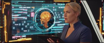Movie still from “The Divergent Series: Insurgent” (2015), directed by Robert Schwentke – A woman holding a tablet in front of a computer screen; Close Up shot, Over the shoulder angle
