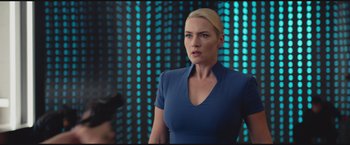 Movie still from “The Divergent Series: Insurgent” (2015), directed by Robert Schwentke – A woman standing in front of a wall with lights; Medium shot, Over the shoulder angle