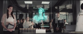 Movie still from “The Divergent Series: Insurgent” (2015), directed by Robert Schwentke – A woman is projected on a glass window; Medium shot, Over the shoulder angle
