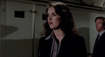 Movie still from “The Driver” (1978), directed by Walter Hill – A woman with long hair wearing a black jacket; Close Up shot, Over the shoulder angle