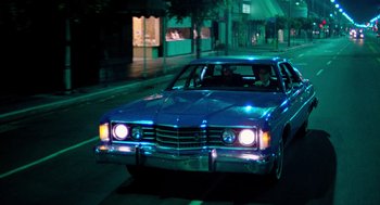 Movie still from “The Driver” (1978), directed by Walter Hill – A car driving down a street at night; Wide shot, Low angle