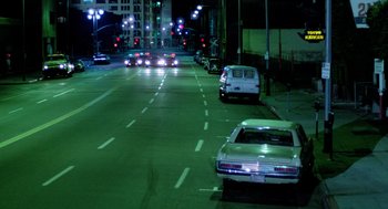 Movie still from “The Driver” (1978), directed by Walter Hill – Cars are parked on the side of the road at night; Extreme Wide shot, High angle
