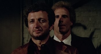 Movie still from “The Driver” (1978), directed by Walter Hill – Two men standing next to each other wearing suits and ties; Close Up shot, Low angle