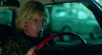 Movie still from “The Driver” (1978), directed by Walter Hill – A man driving a car in the dark; Close Up shot, Over the shoulder angle