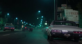 Movie still from “The Driver” (1978), directed by Walter Hill – Cars parked on the side of the road at night; Wide shot, Low angle