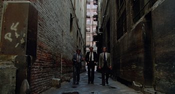 Movie still from “The Driver” (1978), directed by Walter Hill – A group of men in suits walking down a street; Wide shot, High angle