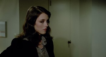 Movie still from “The Driver” (1978), directed by Walter Hill – A woman with long dark hair wearing a black jacket; Close Up shot, Over the shoulder angle