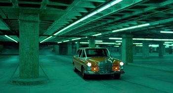 Movie still from “The Driver” (1978), directed by Walter Hill – An orange car is parked in an underground parking garage; Extreme Wide shot, Low angle