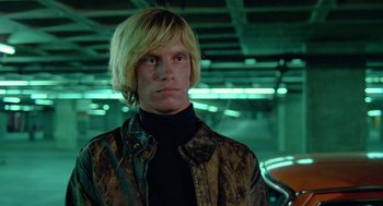 Movie still from “The Driver” (1978), directed by Walter Hill – A man with blonde hair wearing a brown jacket; Close Up shot, Low angle