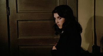 Movie still from “The Driver” (1978), directed by Walter Hill – A young woman standing in front of a wooden wall; Close Up shot, High angle