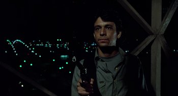 Movie still from “The Driver” (1978), directed by Walter Hill – A man is holding a gun in the dark at night; Close Up shot, Low angle