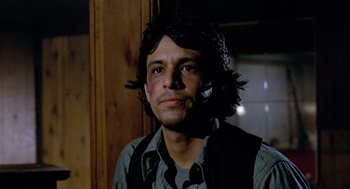 Movie still from “The Driver” (1978), directed by Walter Hill – A man with long black hair is holding a cell phone; Close Up shot, Low angle