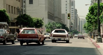 Movie still from “The Driver” (1978), directed by Walter Hill – Cars driving down a street in a city; Wide shot, Low angle