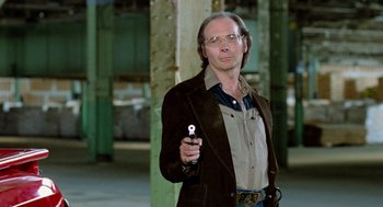 Movie still from “The Driver” (1978), directed by Walter Hill – A man holding a cell phone in his right hand; Medium shot, Low angle