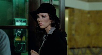 Movie still from “The Driver” (1978), directed by Walter Hill – A woman wearing a black hat and a black jacket; Close Up shot, Over the shoulder angle