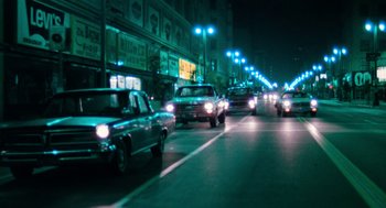 Movie still from “The Driver” (1978), directed by Walter Hill – Cars are driving down a street at night; Extreme Wide shot, High angle