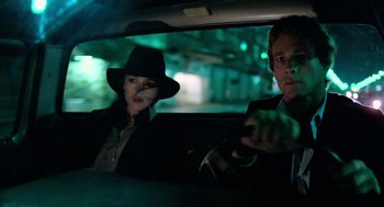 Movie still from “The Driver” (1978), directed by Walter Hill – A man and a woman sitting in the back of a car; Medium shot, Low angle