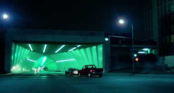 Movie still from “The Driver” (1978), directed by Walter Hill – Two cars are parked in a parking lot under a bridge at night; Extreme Wide shot, Low angle