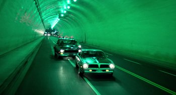 Movie still from “The Driver” (1978), directed by Walter Hill – A group of cars driving down a street; Extreme Wide shot, High angle