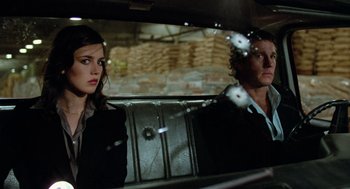 Movie still from “The Driver” (1978), directed by Walter Hill – A man and a woman sitting in the back of a car; Medium shot, Over the shoulder angle