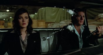 Movie still from “The Driver” (1978), directed by Walter Hill – A man and a woman sitting in the back of a car; Medium shot, Over the shoulder angle