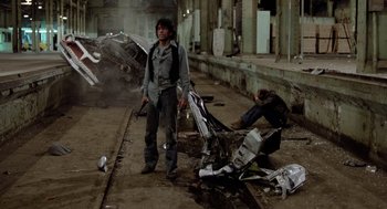 Movie still from “The Driver” (1978), directed by Walter Hill – A man standing next to a pile of trash; Wide shot, Low angle