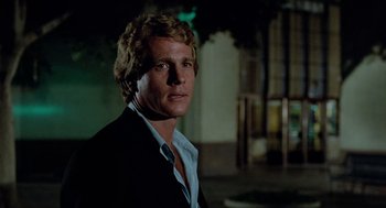 Movie still from “The Driver” (1978), directed by Walter Hill – A person wearing a suit and tie; Close Up shot, Low angle