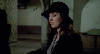 Movie still from “The Driver” (1978), directed by Walter Hill – A woman wearing a black hat and a black jacket; Close Up shot, Over the shoulder angle