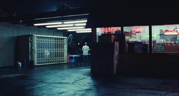 Movie still from “Euphoria” (2019), created by Sam Levinson – A man standing in front of a building at night; Extreme Wide shot, Over the shoulder angle