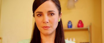 Movie still from “Culture Shock” (2019), directed by Andrew Essig – A woman's face in a yellow room; Close Up shot, Low angle