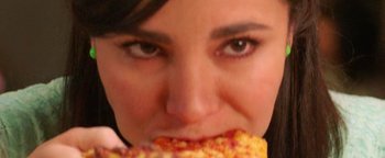 Movie still from “Culture Shock” (2019), directed by Andrew Essig – A person eating a piece of pizza; Extreme Close Up shot, High angle