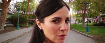 Movie still from “Culture Shock” (2019), directed by Andrew Essig – A woman's face in a parking lot; Close Up shot, High angle