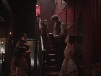 Movie still from “The Electrical Life of Louis Wain” (2021), directed by Will Sharpe – A group of people standing on a set of stairs; Wide shot, Over the shoulder angle